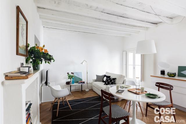 mini appartement de deux pièces, salon, salle à manger, canapé blanc, fausse cheminée, poutres apparentes blanches