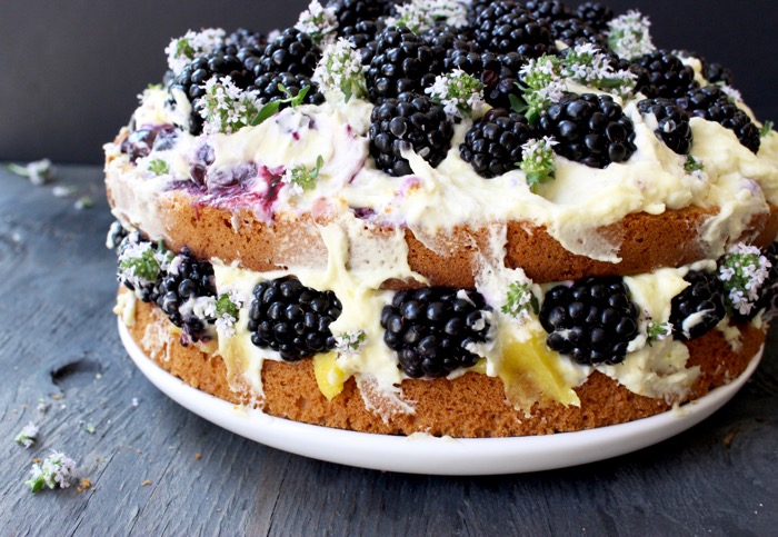 Gâteau à l'huile d'olive et au citron avec garniture de mascarpone au citron et au curd, garnie de mûres fraîches et de fleurs de thym 