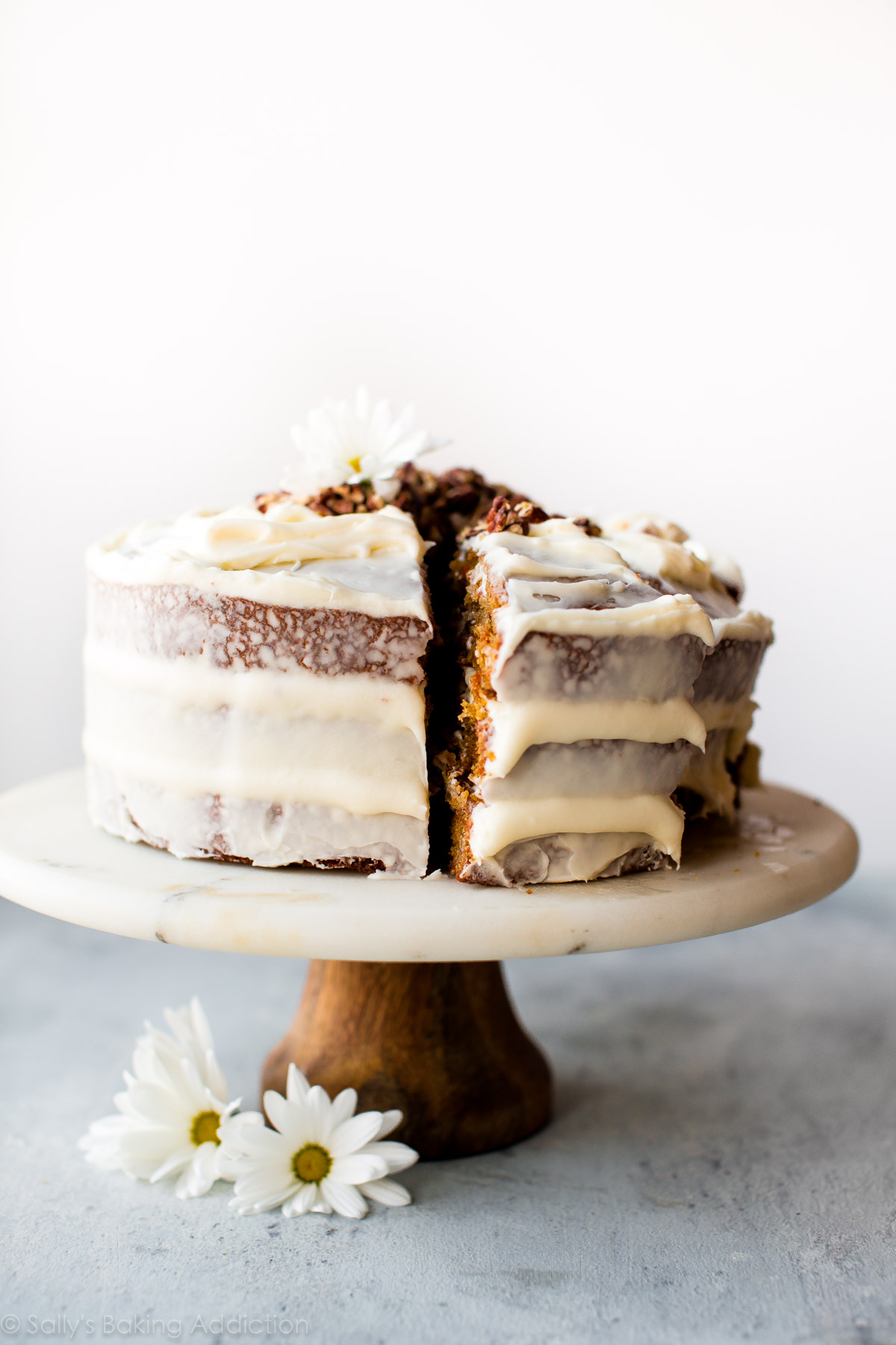 Gâteau aux carottes avec glaçage au fromage à la crème sur un support à gâteaux en marbre et bois