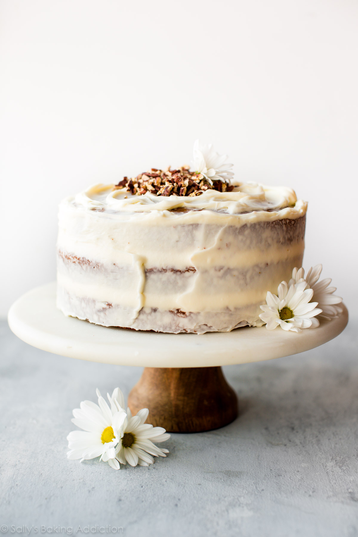 Gâteau aux carottes avec glaçage au fromage à la crème sur un support à gâteaux en marbre et bois