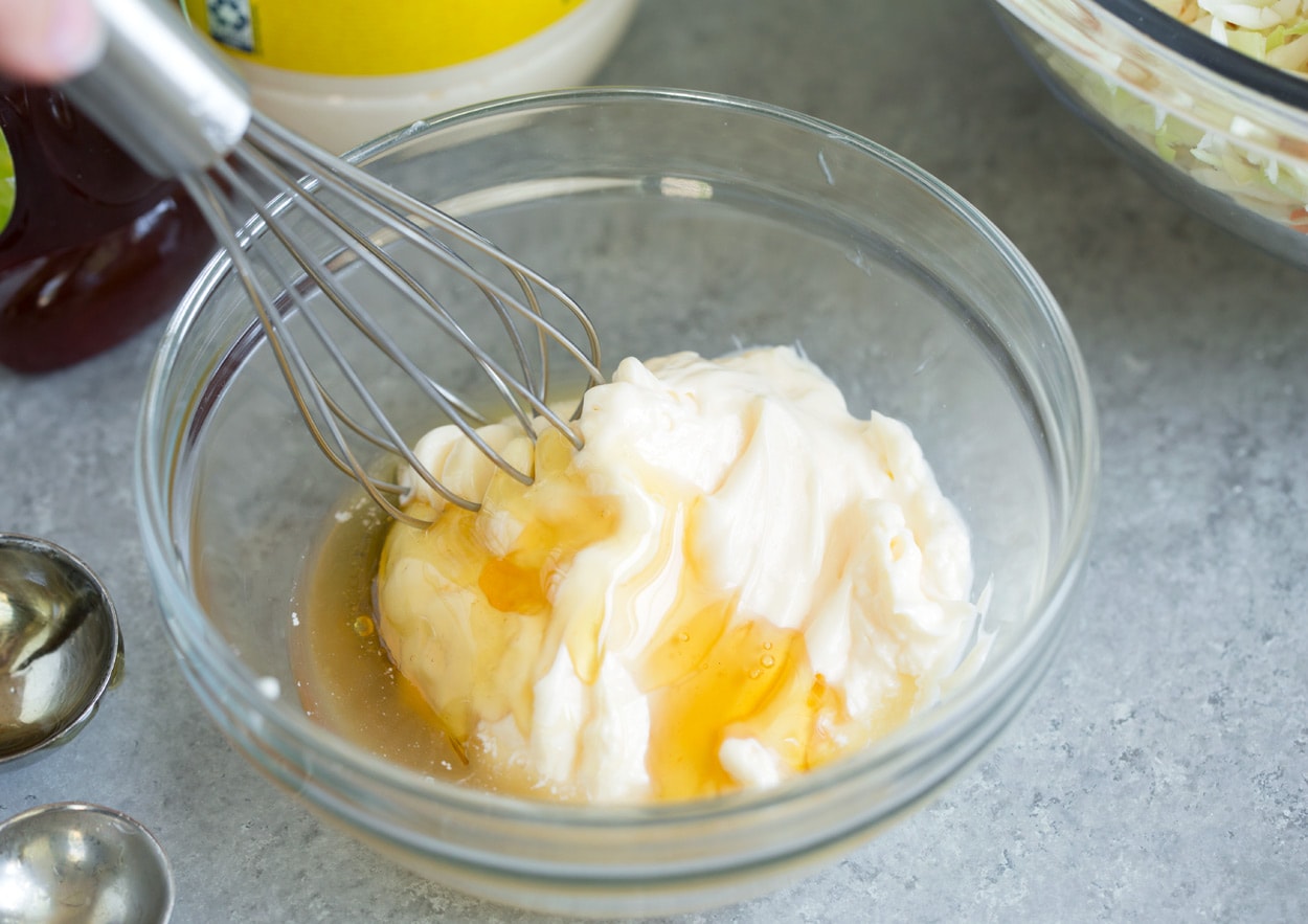 Recette de salade de chou Faire de la vinaigrette pour salade de chou dans un bol à mélanger avec 3 ingrédients dont de la mayonnaise, du miel et du vinaigre de cidre de pomme.