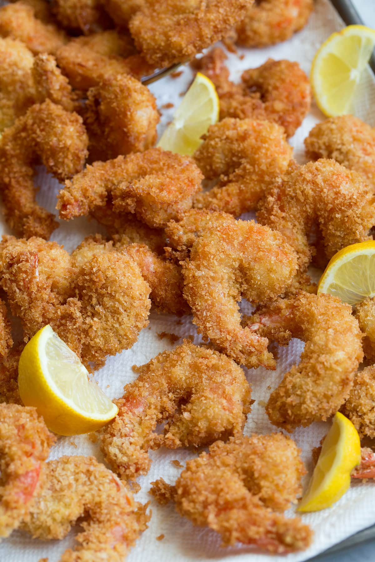 Crevette frite Photo en gros plan de crevettes frites en croûte de panko empilées sur une plaque recouverte de papier essuie-tout.