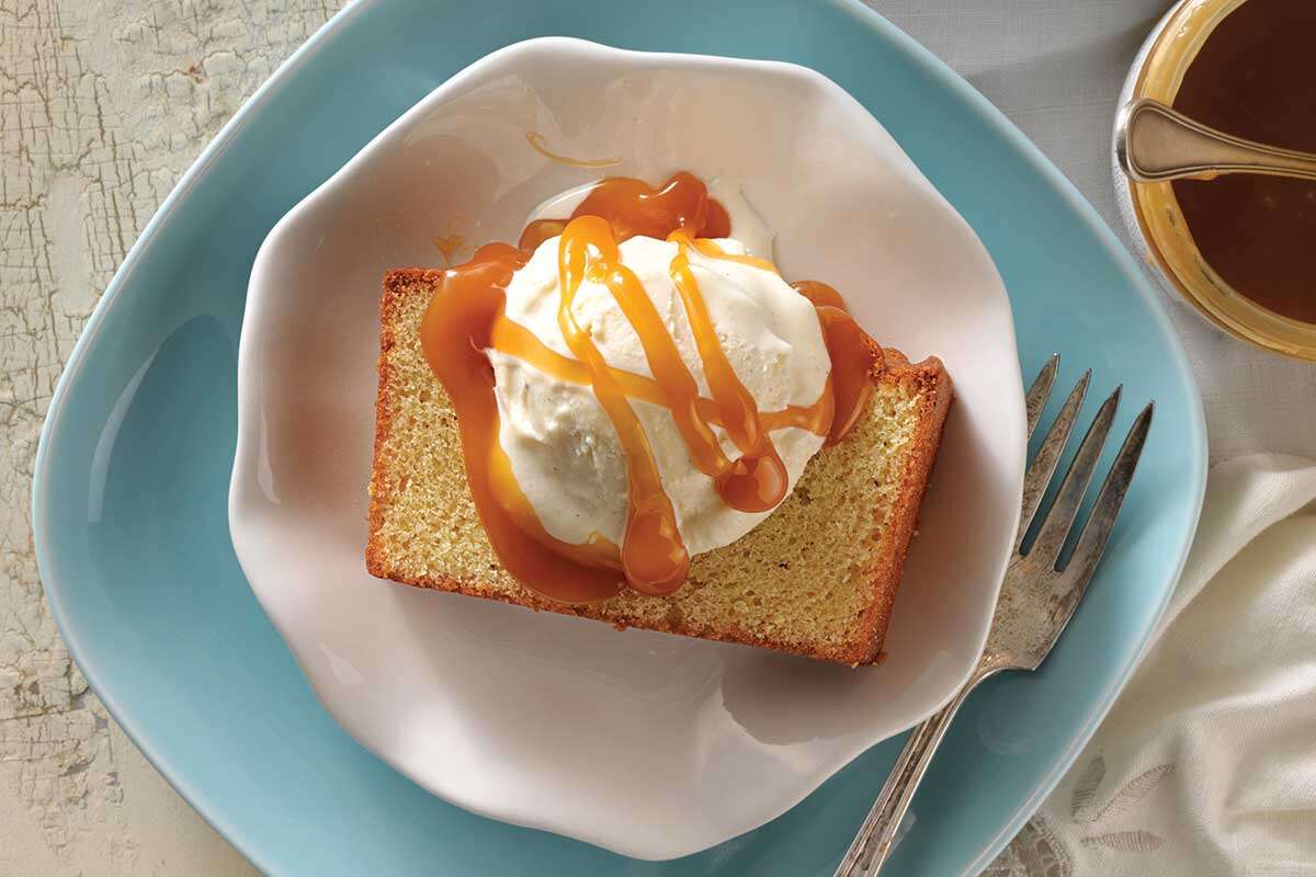 Une tranche de quatre-quarts avec une boule de glace à la vanille et une sauce au caramel sur le dessus