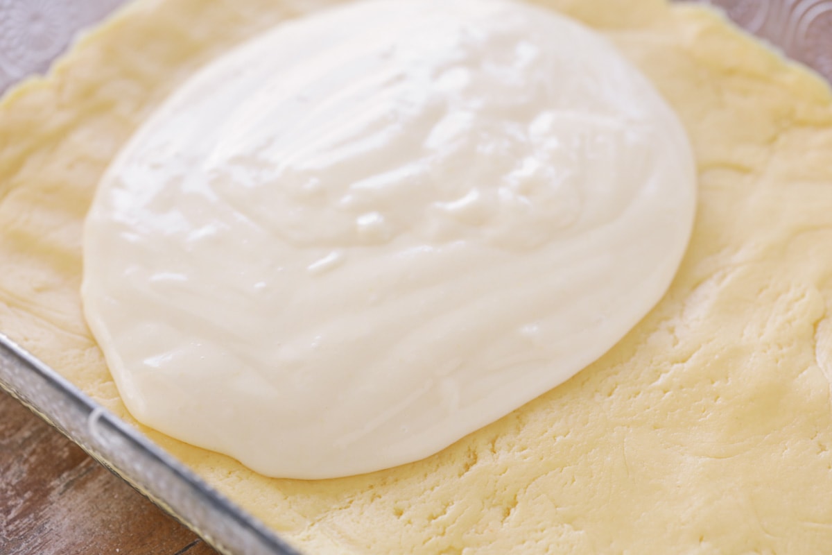 Le gâteau au beurre gluant est un dessert simple et incroyablement délicieux avec une croûte de pâte à gâteau et un dessus de fromage à la crème doux et gluant qui le rend addictif! Ajouter une couche de fromage à la crème gluant sur la croûte