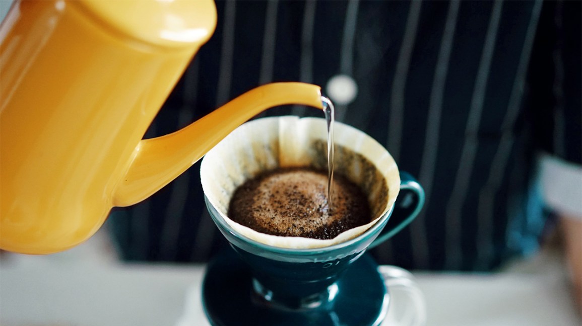 L'eau chaude est versée dans un filtre avec du café