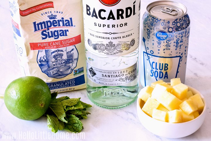 Ingrédients Mojito à l'ananas disposés sur un comptoir en marbre.