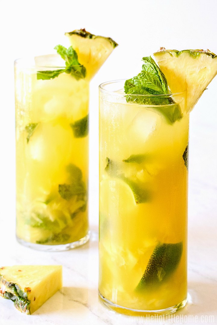 Deux boissons au rhum à l'ananas sur un comptoir en marbre.