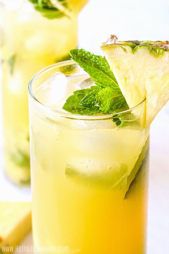 Un gros plan de la boisson finie garnie d'un quartier d'ananas et de menthe fraîche.