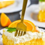 graphique pinterest d'un morceau de gâteau de cueillette de cochon orange sur une assiette blanche avec une tranche d'orange et deux feuilles de menthe sur le dessus et une fourchette creusant dans le gâteau, dit : 