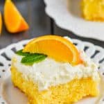 recette de gâteau à l'orange sur une assiette garnie d'une orange fraîche