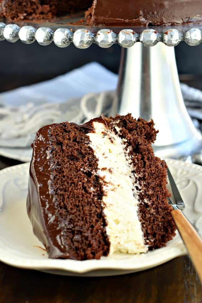 Tranche de gâteau au chocolat avec garniture à la crème et ganache au chocolat.