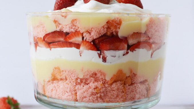 Layered strawberry dessert in a clear trifle bowl. 