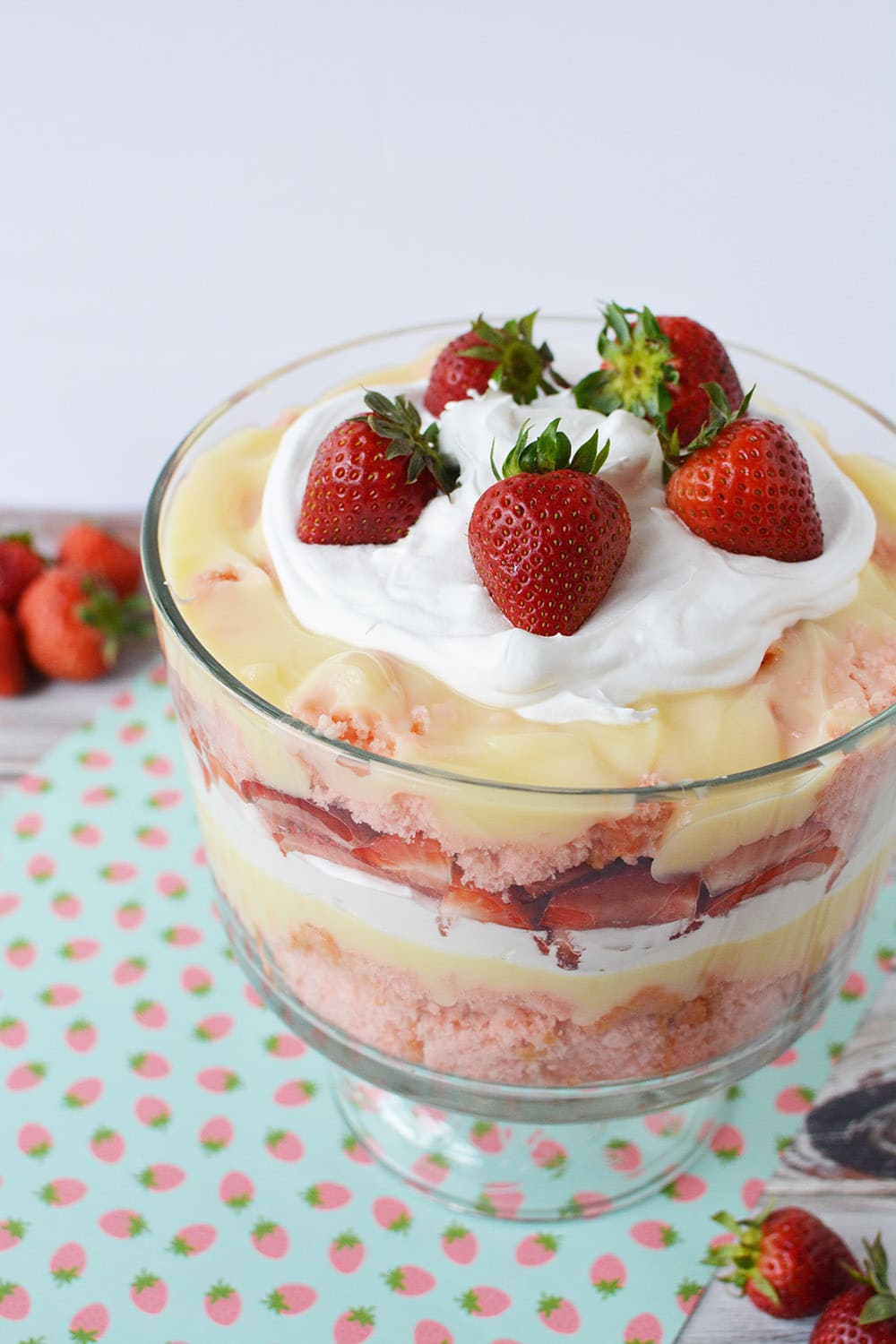 Couches de gâteau aux fraises, pudding au fromage, crème fouettée et fraises dans un bol à bagatelle