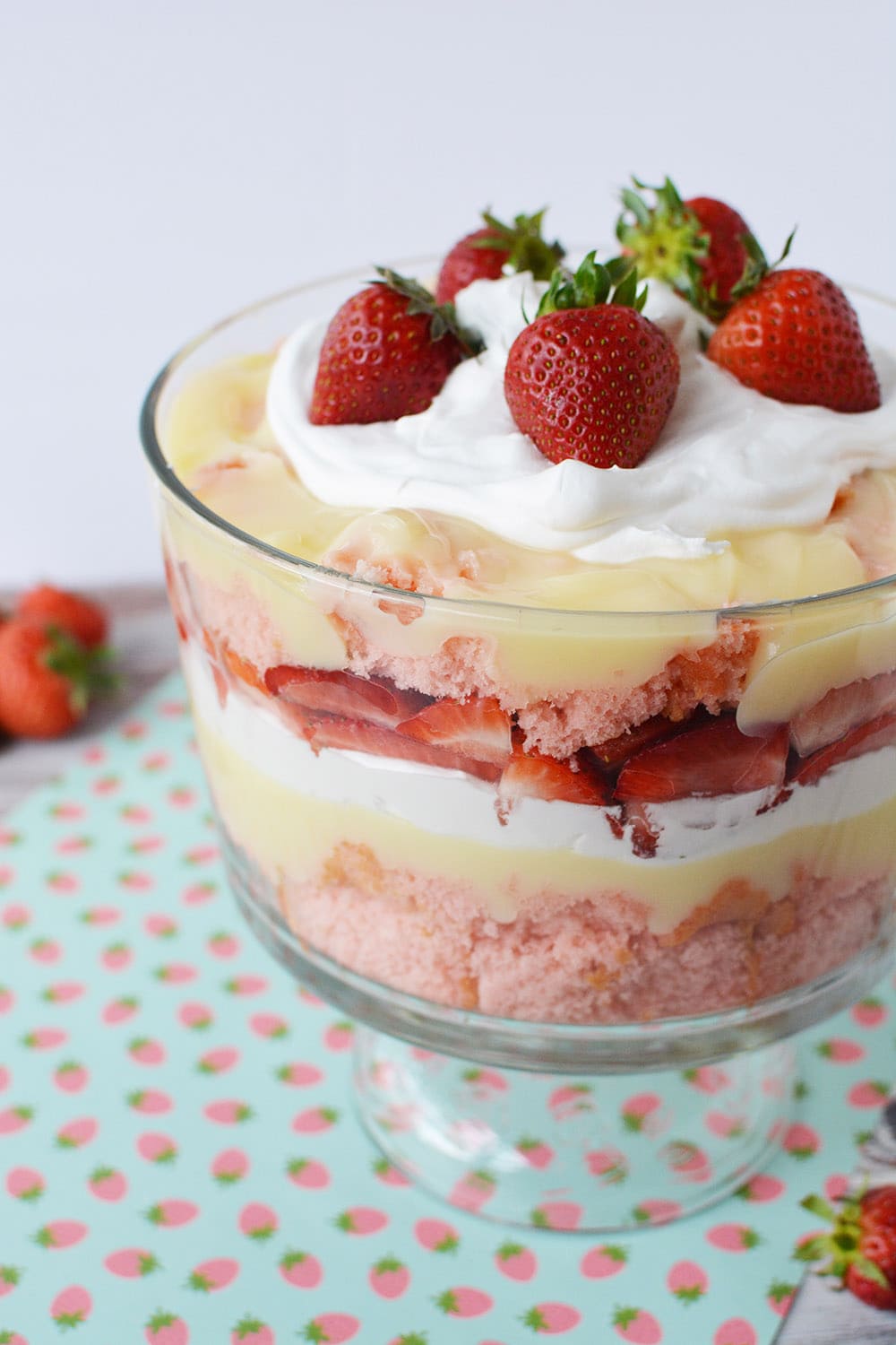 Un bol à bagatelle avec des couches de gâteau, des fraises, du pudding et de la crème fouettée garnis de baies fraîches.
